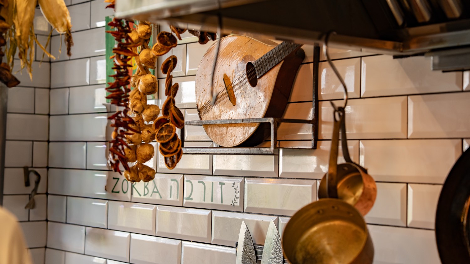 A bouzouki and garlic braids on the tiled wall